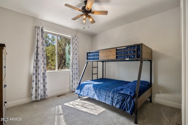 carpeted bedroom featuring baseboards, visible vents, and a ceiling fan