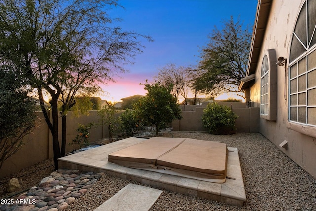 patio terrace at dusk with a covered hot tub