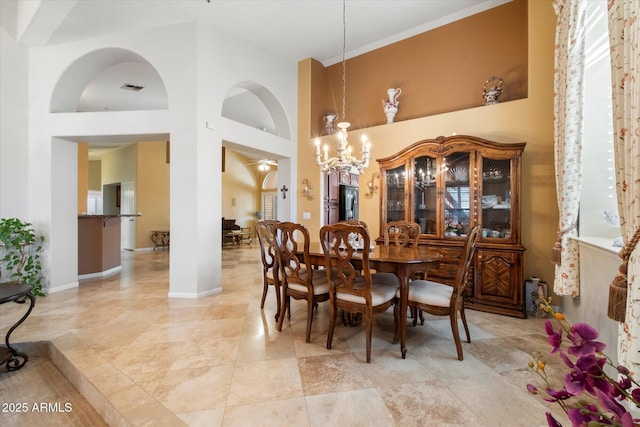 dining area featuring a high ceiling and a notable chandelier