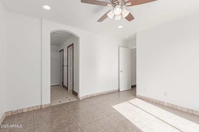 tiled empty room featuring ceiling fan