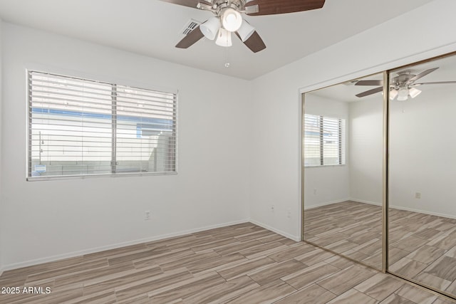 unfurnished bedroom with ceiling fan and a closet