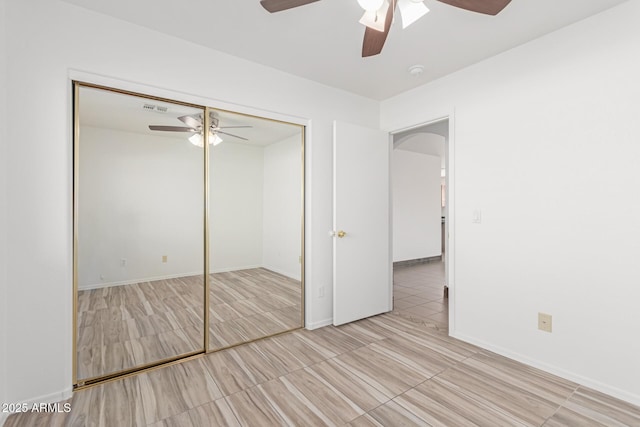 unfurnished bedroom featuring ceiling fan and a closet