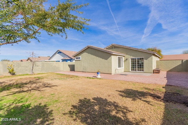 back of house with a patio and a yard