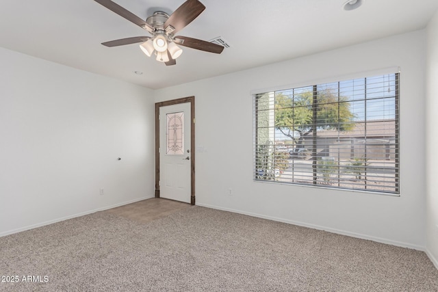 carpeted spare room with ceiling fan