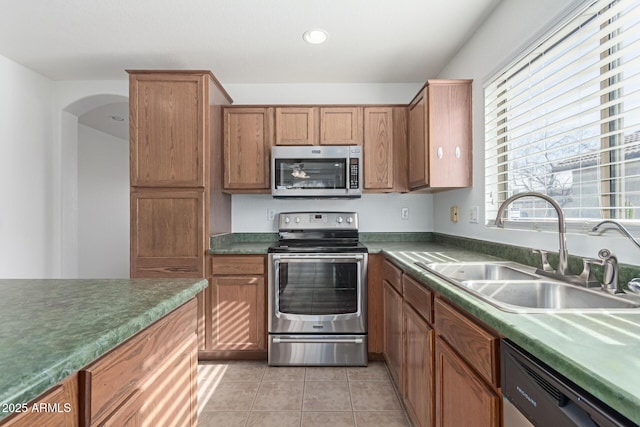 kitchen featuring stainless steel appliances, sink, and light tile patterned floors