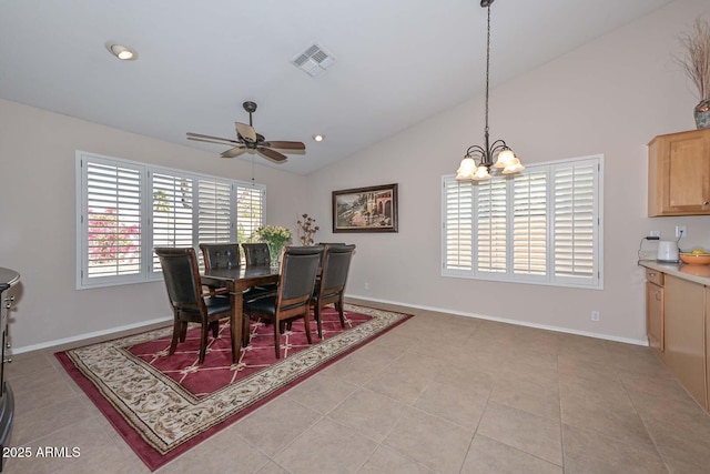 dining space with ceiling fan with notable chandelier, lofted ceiling, and light tile patterned floors