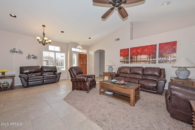 living room with ceiling fan with notable chandelier, light tile patterned floors, and high vaulted ceiling