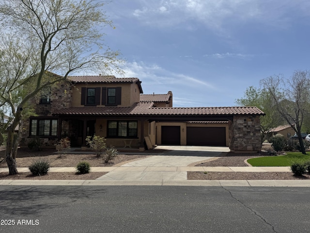 mediterranean / spanish house featuring stone siding, a garage, stucco siding, a tiled roof, and driveway