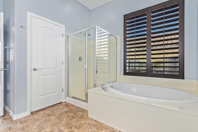 bathroom with tile patterned flooring and shower with separate bathtub