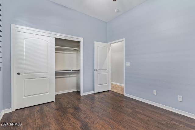 unfurnished bedroom featuring dark hardwood / wood-style flooring and a closet