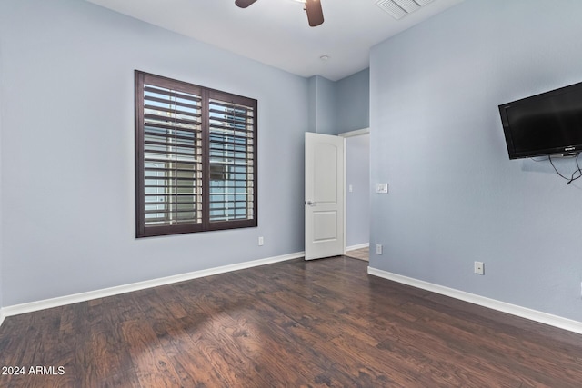 empty room with dark hardwood / wood-style floors and ceiling fan