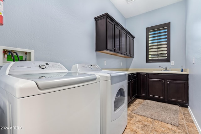 laundry room featuring cabinets, separate washer and dryer, and sink