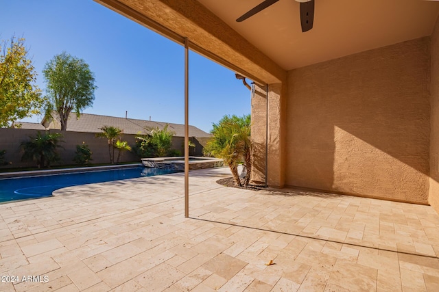 view of patio featuring ceiling fan and a pool with hot tub