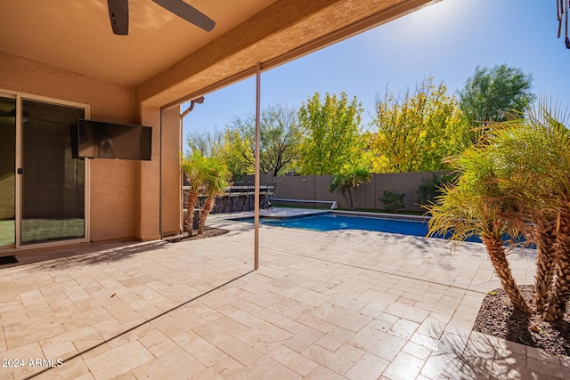 view of swimming pool featuring ceiling fan and a patio area