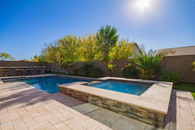 view of pool with an in ground hot tub