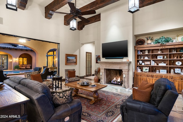 living room featuring beamed ceiling, a towering ceiling, and ceiling fan