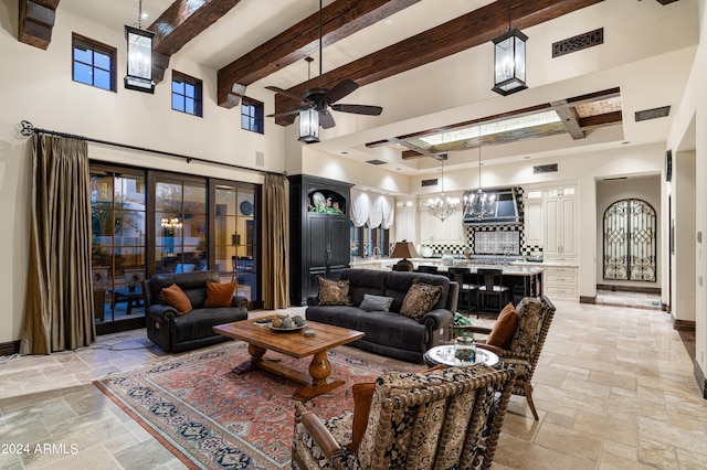 living room featuring a high ceiling, ceiling fan with notable chandelier, and beam ceiling