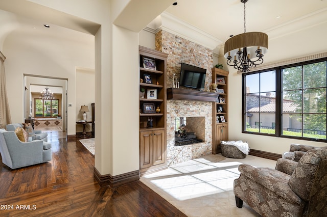 living room with dark hardwood / wood-style flooring, built in features, a fireplace, and a chandelier