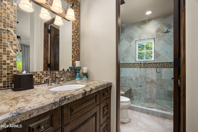 bathroom with vanity, tile patterned flooring, toilet, walk in shower, and tile walls