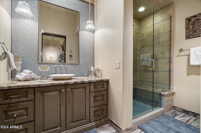 bathroom with decorative backsplash, vanity, and a shower with shower door