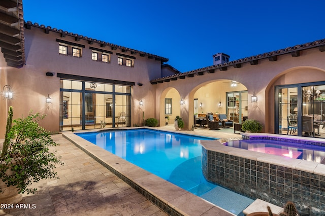 pool at twilight featuring an outdoor living space and a patio