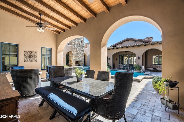 view of patio / terrace with ceiling fan and an outdoor fireplace