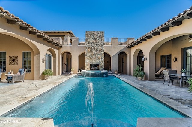 view of pool with a patio area, pool water feature, ceiling fan, and an in ground hot tub