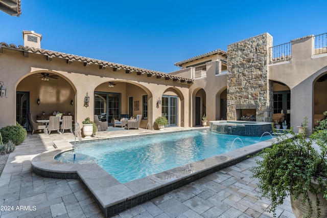 view of pool with an outdoor hangout area, pool water feature, ceiling fan, an in ground hot tub, and a patio area