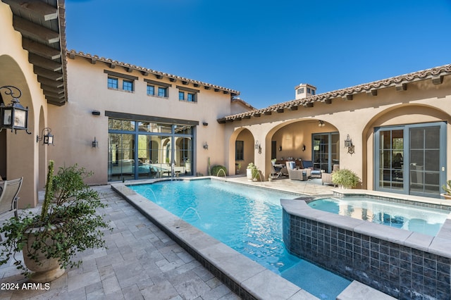 view of swimming pool featuring an in ground hot tub, pool water feature, and a patio area