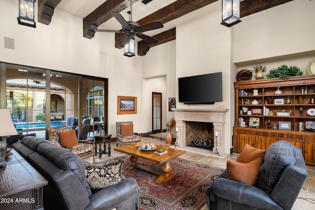 living room with ceiling fan, beam ceiling, and a high ceiling