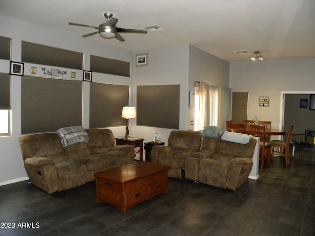 living room featuring ceiling fan and dark tile floors