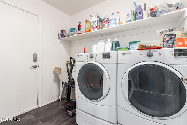 laundry area with washing machine and clothes dryer and dark tile flooring