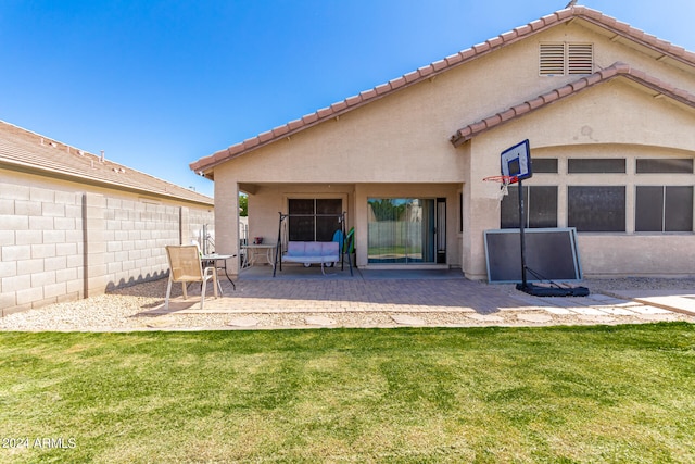 rear view of house featuring a lawn and a patio area