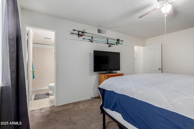 carpeted bedroom with a textured ceiling, connected bathroom, visible vents, and a ceiling fan