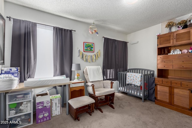 carpeted bedroom with a crib and a textured ceiling