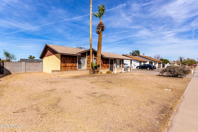 view of front of property with driveway, covered porch, and fence