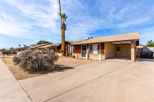 ranch-style home featuring an attached carport and concrete driveway