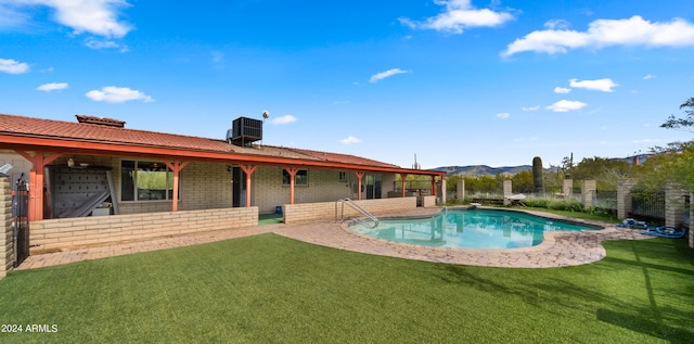 view of swimming pool featuring a patio area, cooling unit, and a lawn