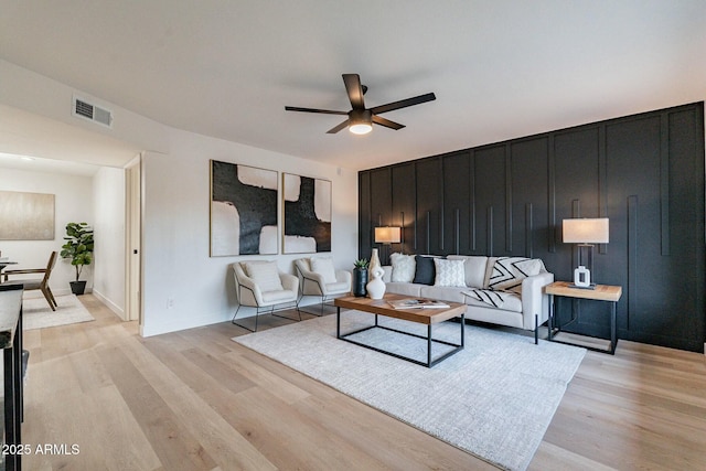 living room featuring light hardwood / wood-style floors and ceiling fan