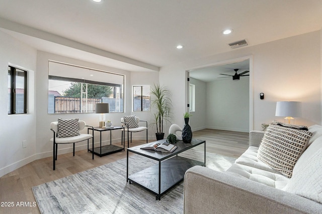 living room featuring light hardwood / wood-style floors and ceiling fan