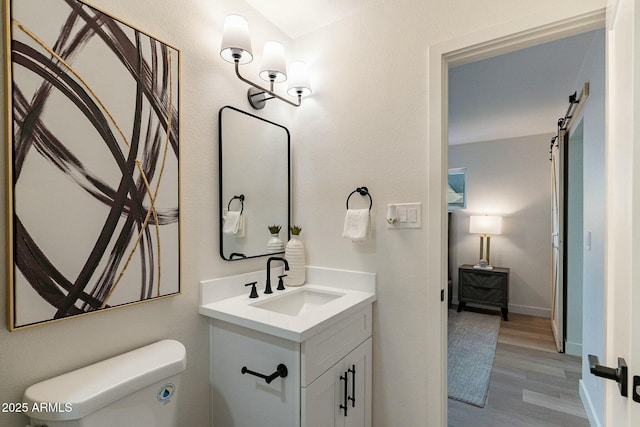 bathroom featuring vanity, hardwood / wood-style flooring, and toilet