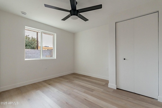 unfurnished bedroom with ceiling fan, a closet, and light hardwood / wood-style flooring