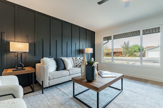 living room with ceiling fan and light hardwood / wood-style flooring