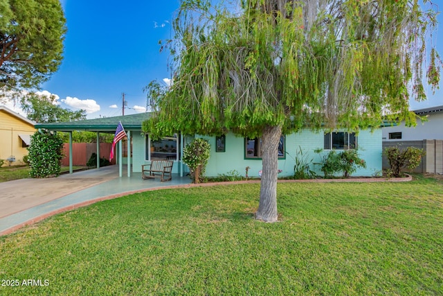 view of front facade with concrete driveway, fence, a front yard, and a carport