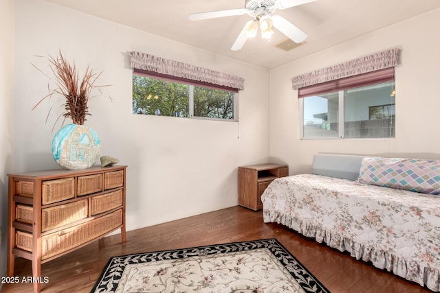 bedroom with a ceiling fan, visible vents, and wood finished floors