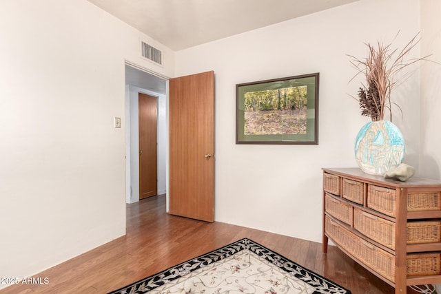 corridor with visible vents and wood finished floors