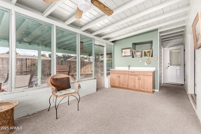 sunroom / solarium featuring a ceiling fan and beamed ceiling