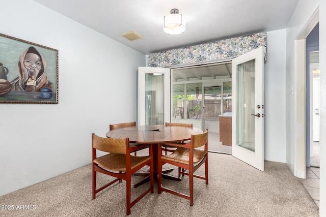dining space with visible vents, light carpet, and french doors