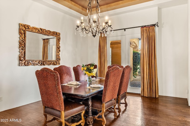 dining space with wood-type flooring and an inviting chandelier