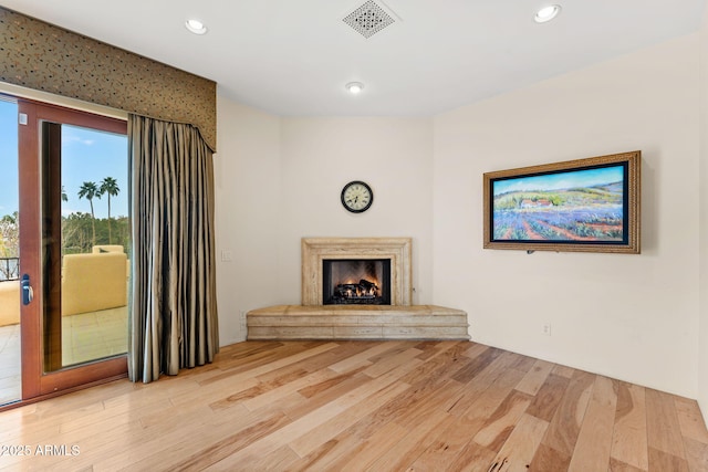 unfurnished living room with a fireplace, wood finished floors, visible vents, and recessed lighting